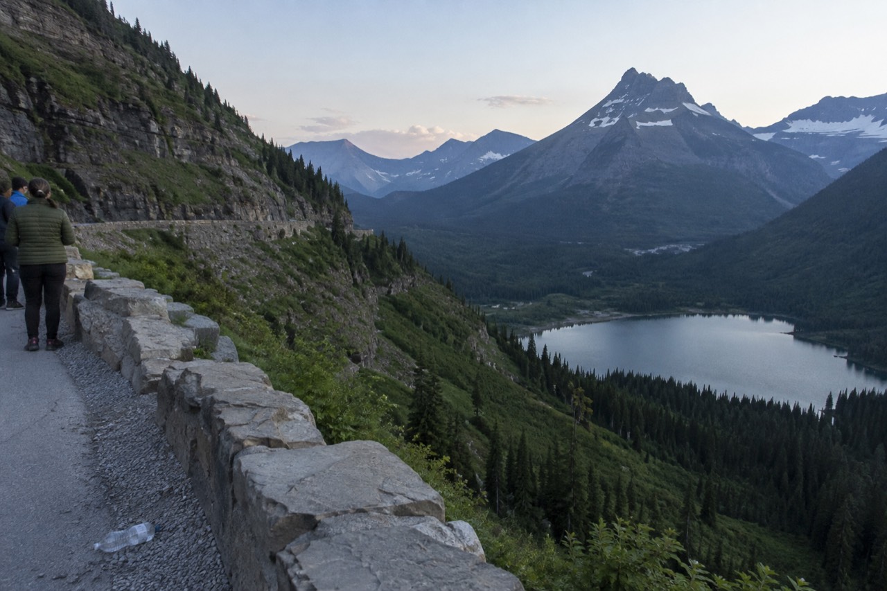 Going-to-the-Sun Road curving along a green mountainside above a glacial lake