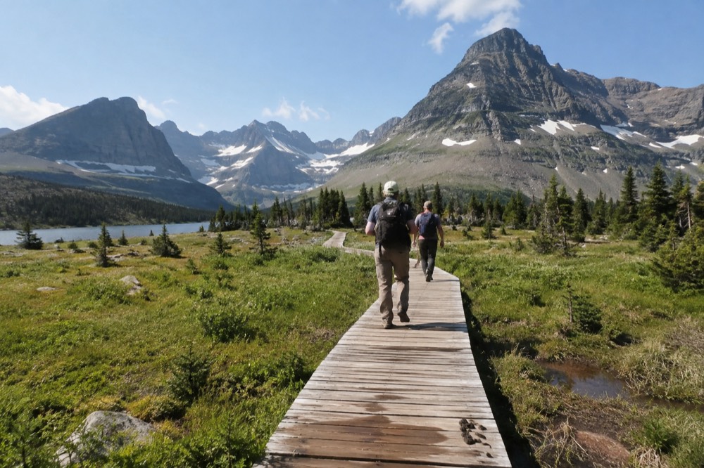 Logan Pass visitor area with boardwalk trails crossing a high alpine meadow below rocky peaks