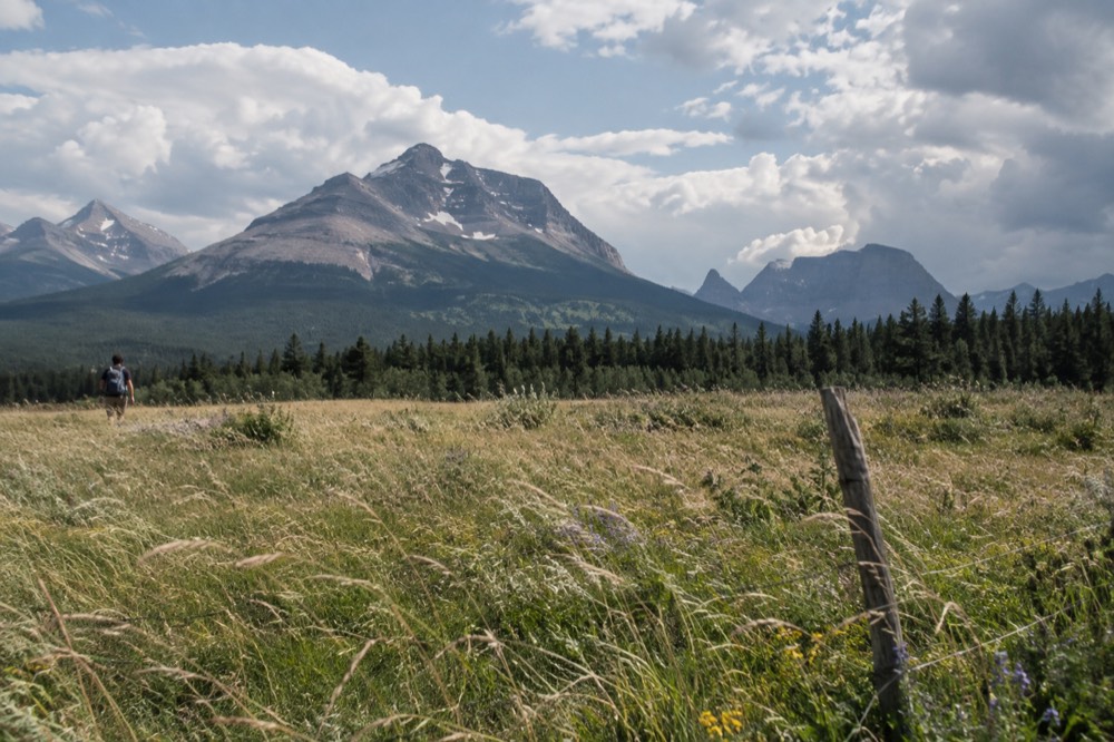 Wide open prairie meeting a dramatic mountain front under a wide sky