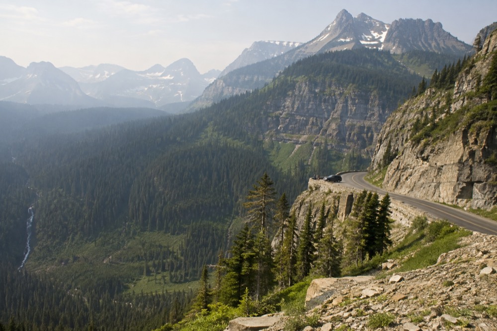 Going-to-the-Sun Road curving along a cliff face below jagged peaks