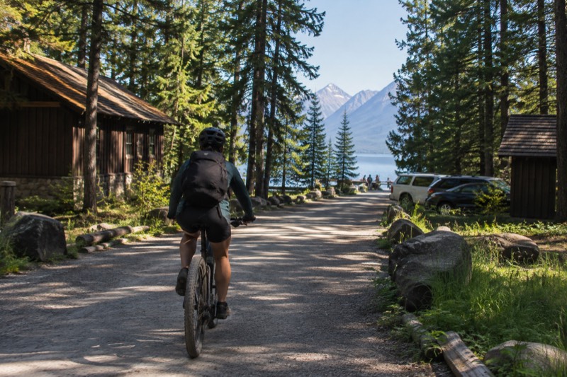 Electric bikes on Camas Road in Glacier National Park with forested mountains rising behind the riders