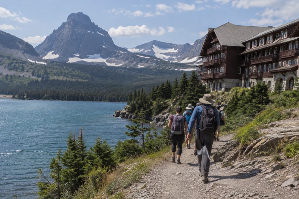 A small group of hikers following a guide along a lakeshore path