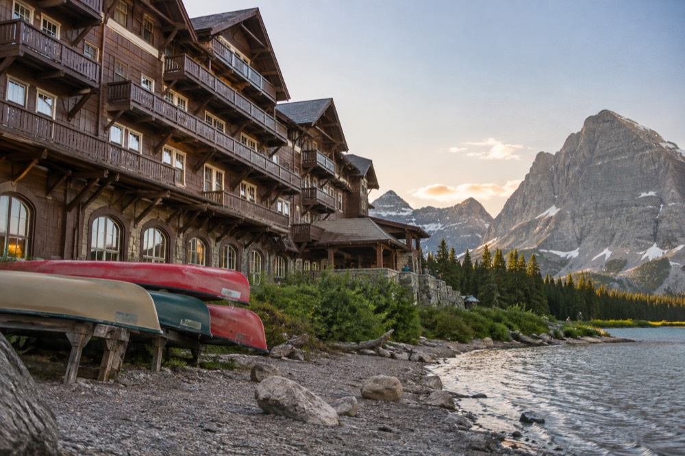Alpine lake surrounded by jagged peaks with a historic lodge on the near shore