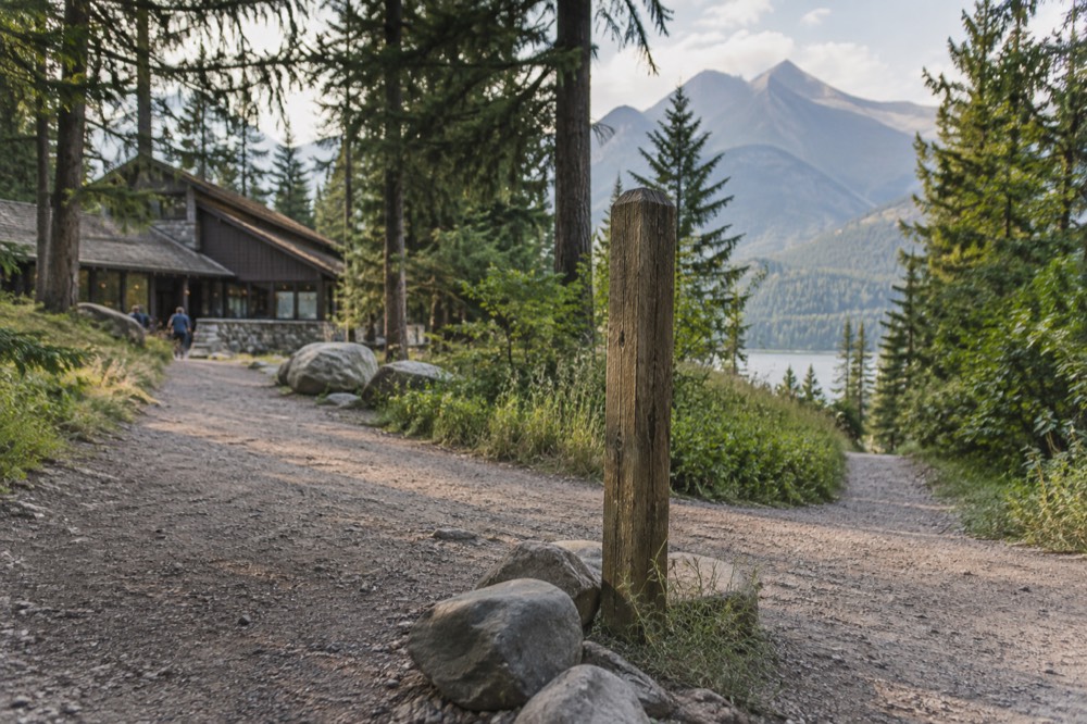 A trail sign at a junction with mountains in the background