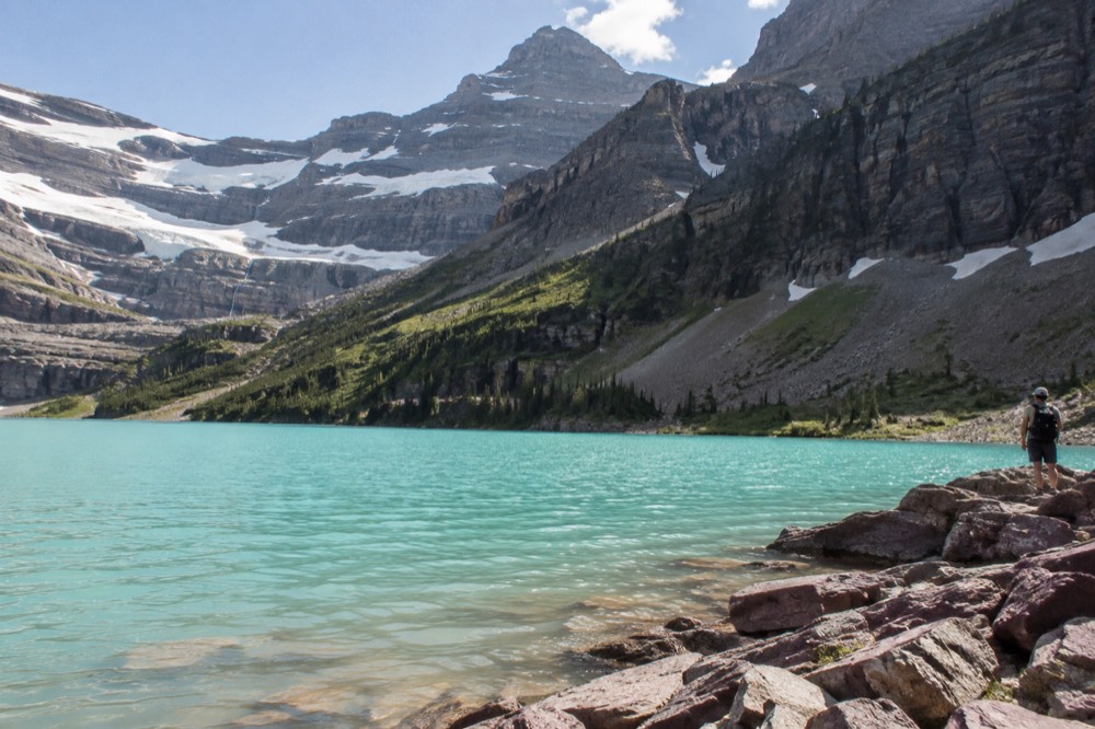 A turquoise alpine lake surrounded by evergreen forest and steep mountain slopes