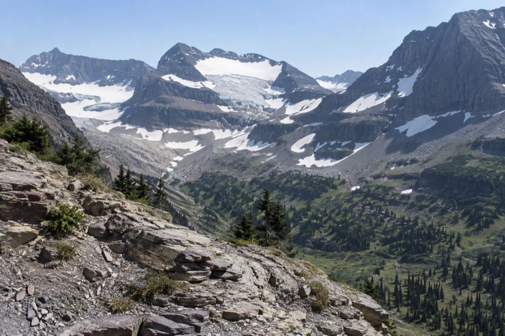 A glacier nestled in a high mountain basin between sharp rock ridges