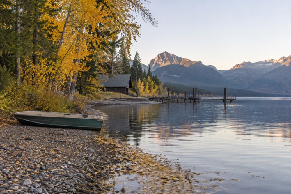 Golden aspen trees along a quiet lakeshore in early autumn