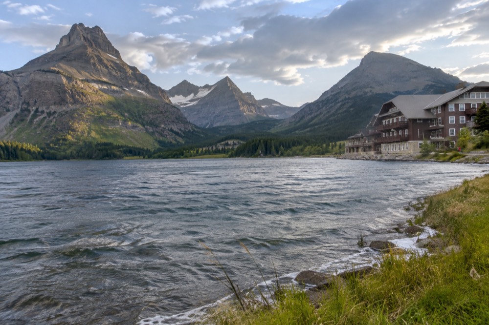 Mountain peaks reflected in a still lake with forested slopes below