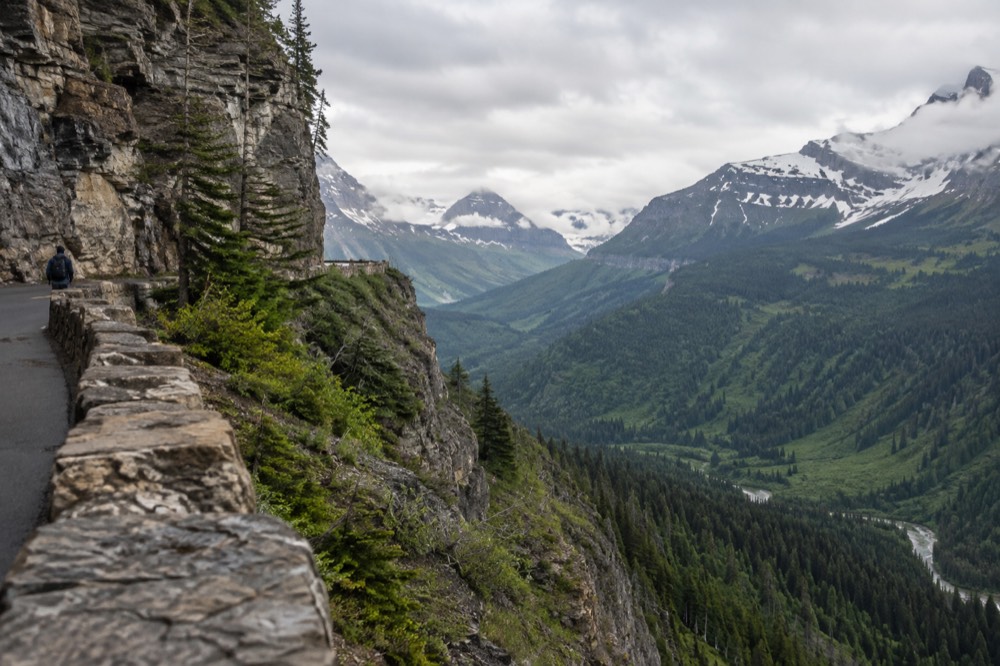 A narrow mountain road cut into a cliff face above a deep valley