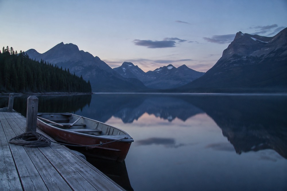 A calm lake with mountains reflected in still water