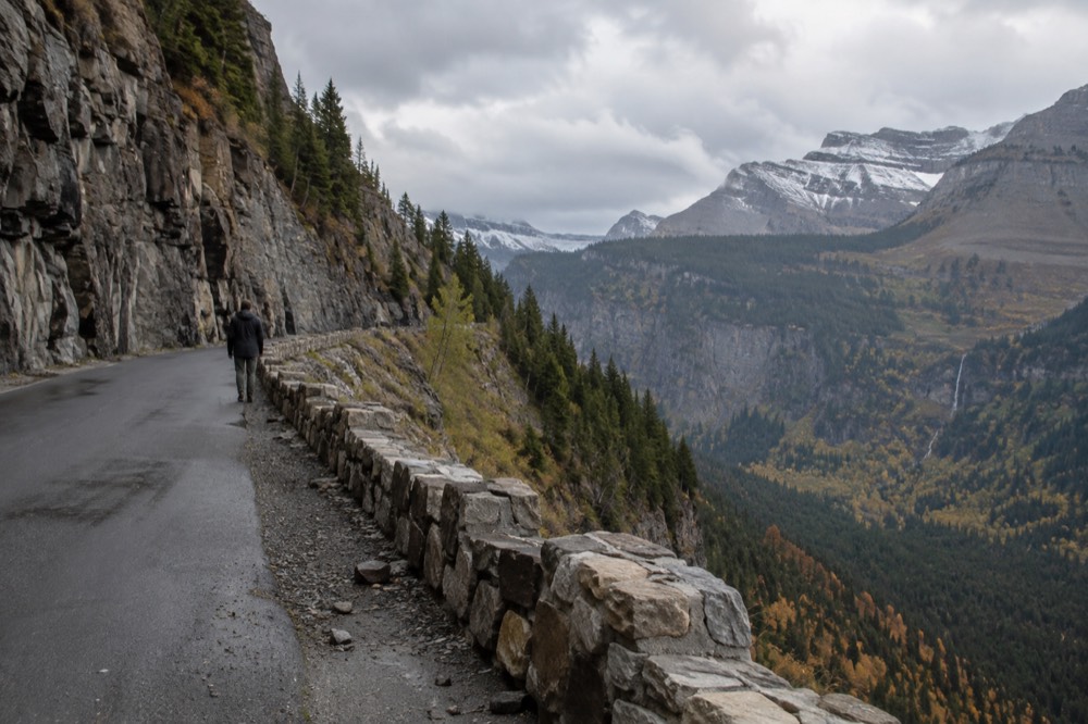A narrow stone-sided road cut into a cliff face with a steep drop below