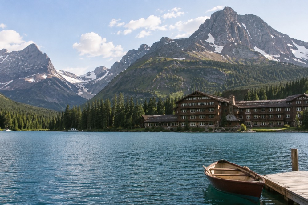 A turquoise lake ringed by mountains with a small hotel on its shore