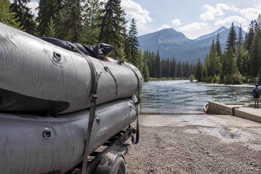 Rafts on the Middle Fork of the Flathead River with forested banks and mountains in the background.