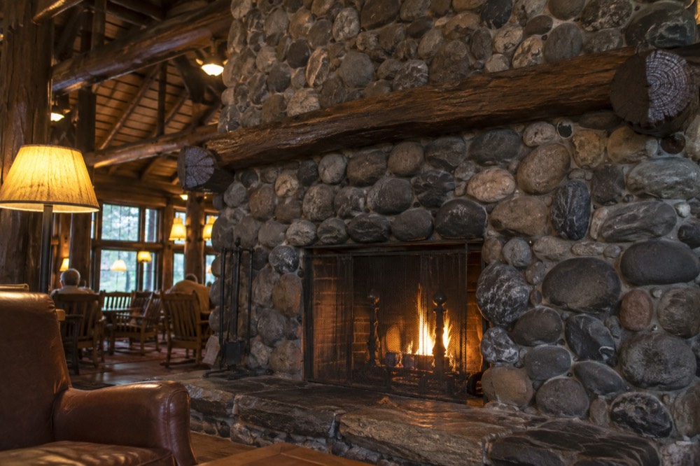 Lake McDonald Lodge lobby with a large stone fireplace and wooden beams.
